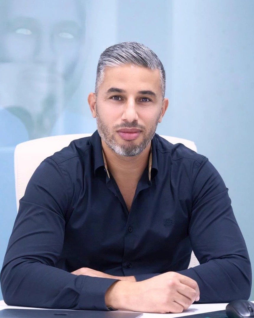 Dr. Hamza Alzawahra, în cămașă bleumarin, la biroul din cabinetul clinicii ReActive Health