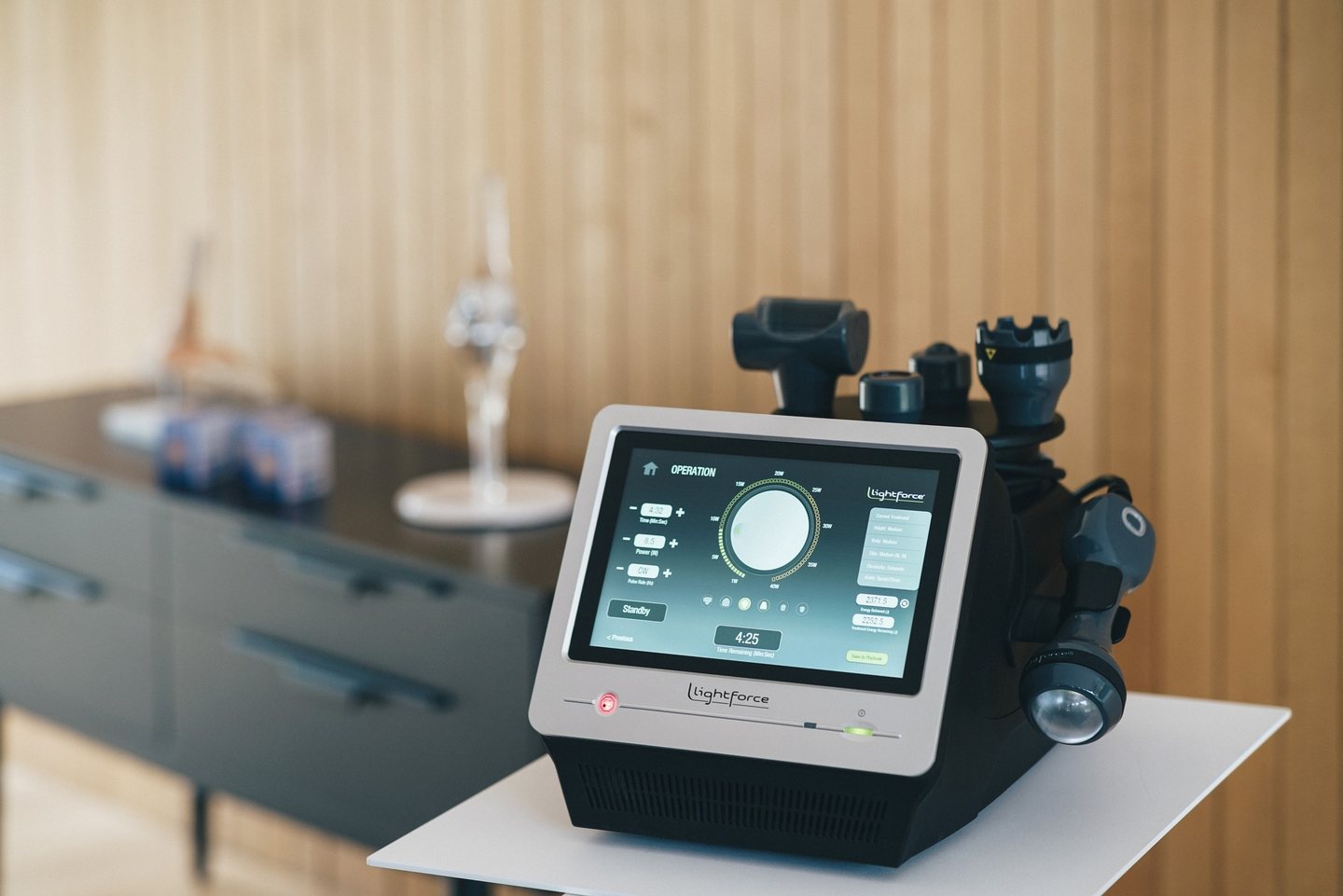 Consola laserului LightForce 25W cu ecran tactil, așezată pe un birou în cabinet
